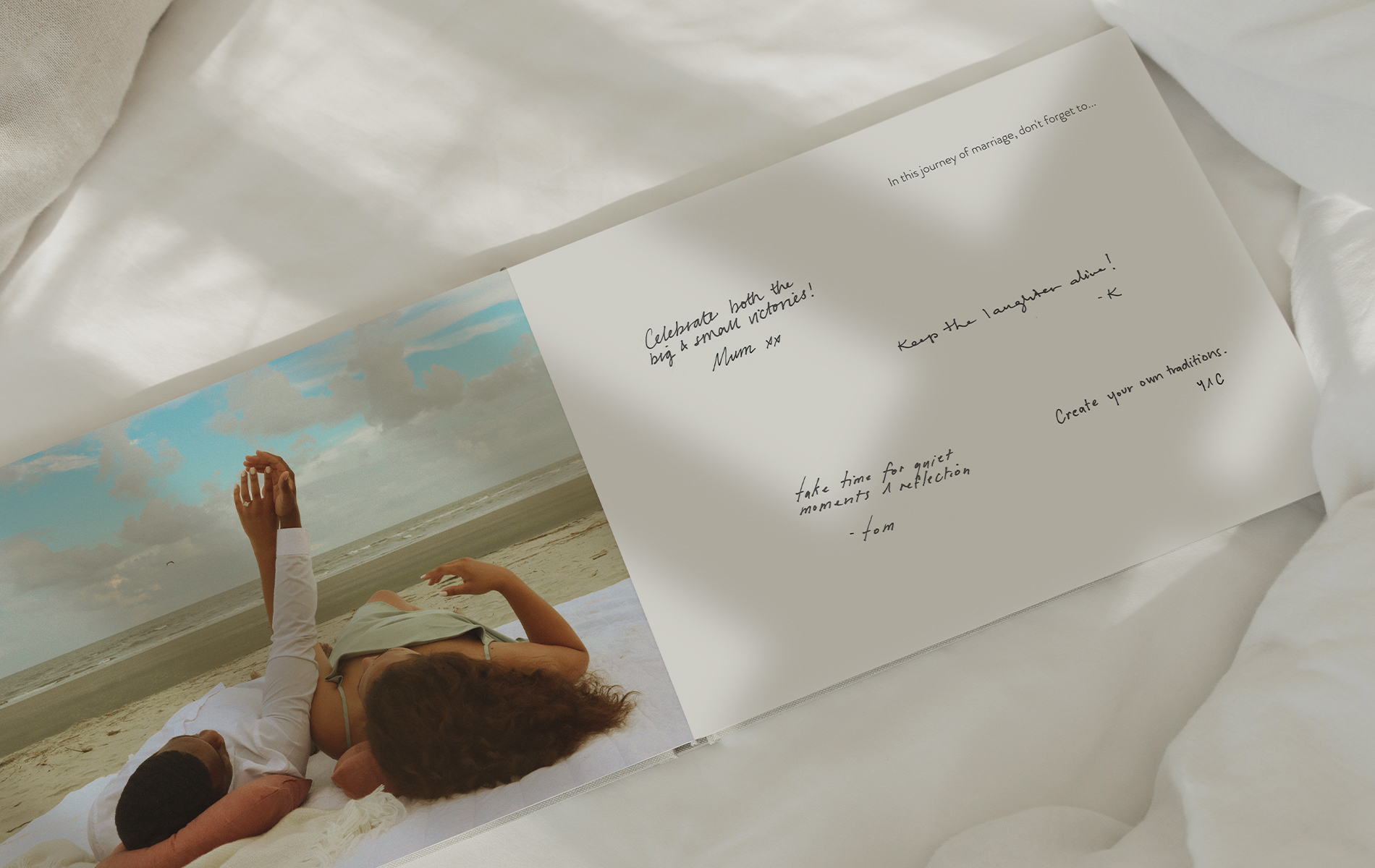 Couple holding hands image on Wedding Guest Book on bed