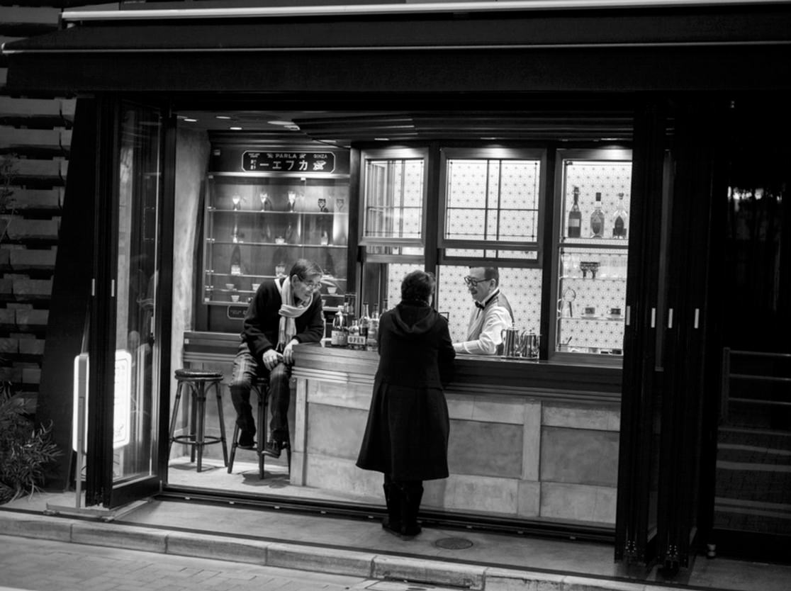 Three people at small wine bar.