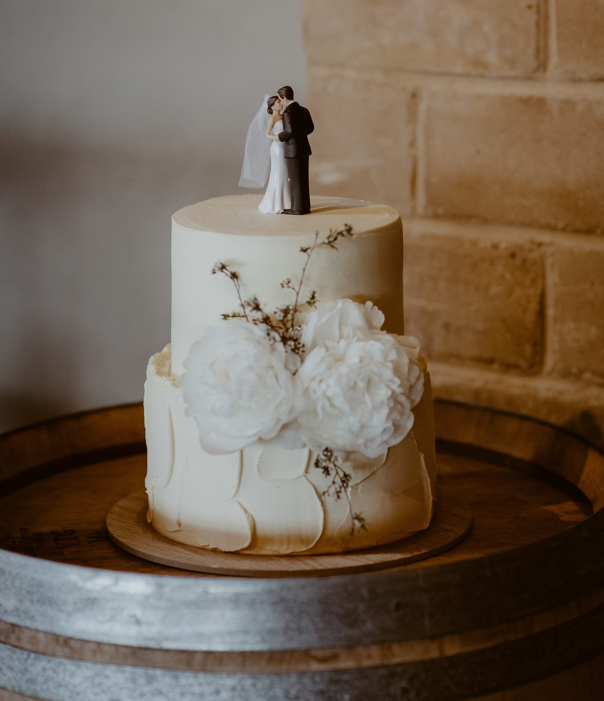 Two tiered wedding cake with bride and groom cake toppers