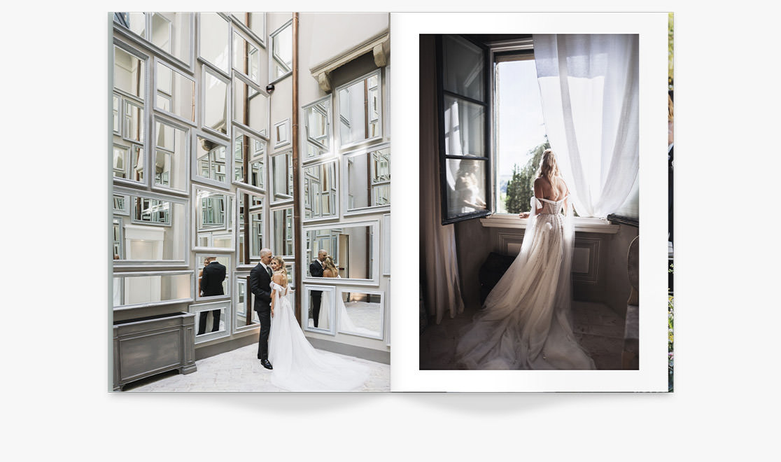 Newlywed couple stand in front of white framed mirror wall with high ceiling