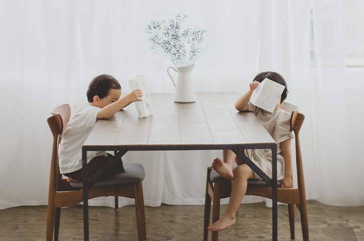 Two sibling sitting at a table together