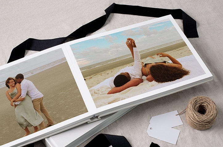 Open photo book with photos of couple on beach