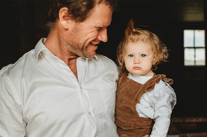Father holding and smiling at his daughter