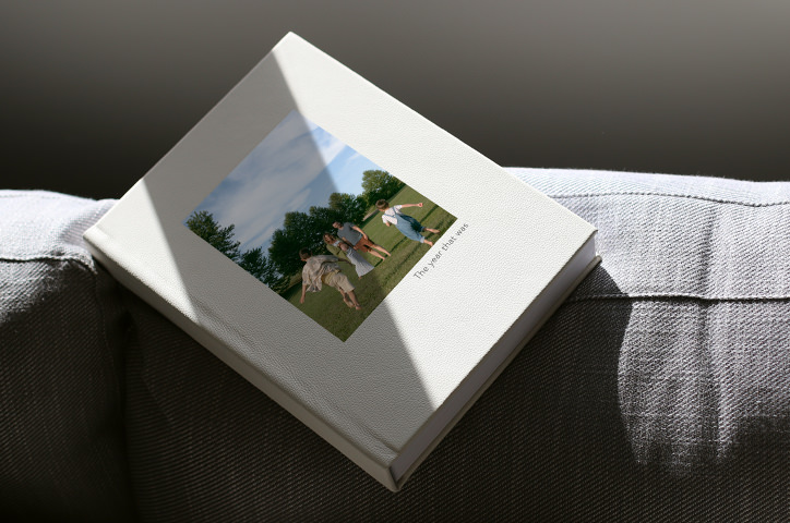 Portrait Photo Book laying on grey couch edge in filtered sunlight