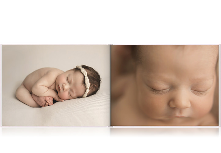 Livro fotográfico de paisagem com duas fotos de um bebê dormindo.
