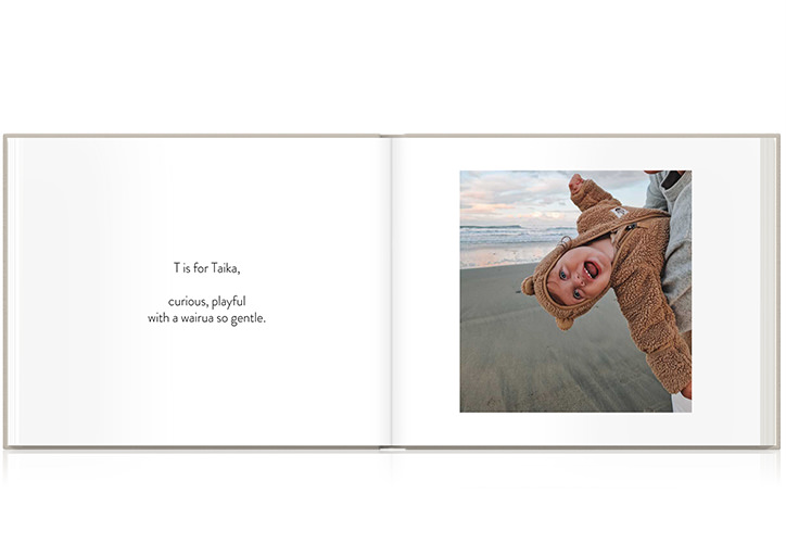 Photo Album with baby in bear onesie playing happily on beach