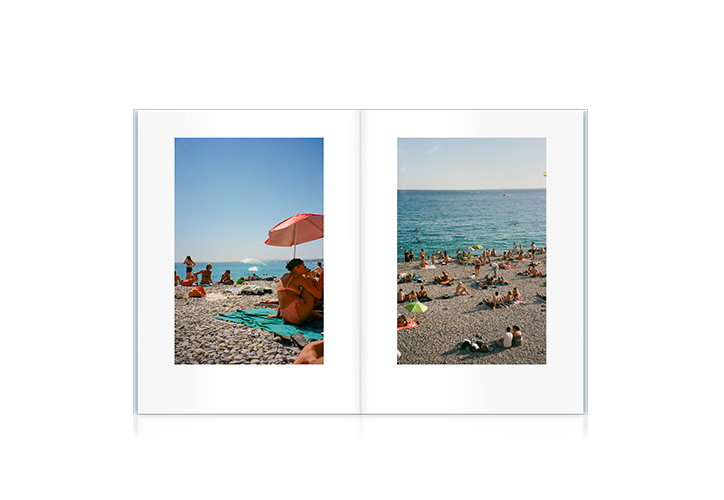 Large crowded beach scattered with people and sun umbrellas under sunny blue sky