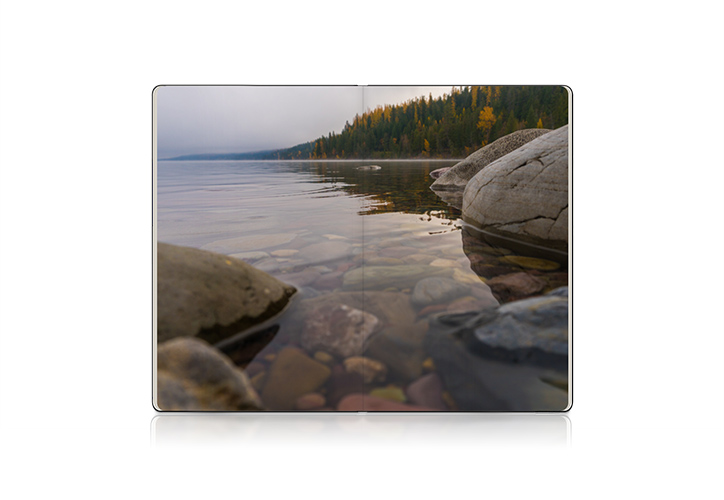 Open Moleskine photo book showing spread of lake image