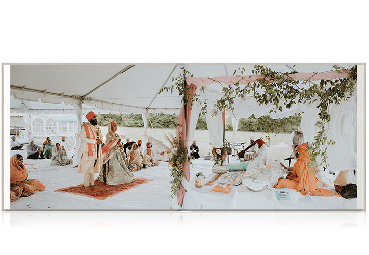 Double page spread of wedding ceremony on landscape photo book.