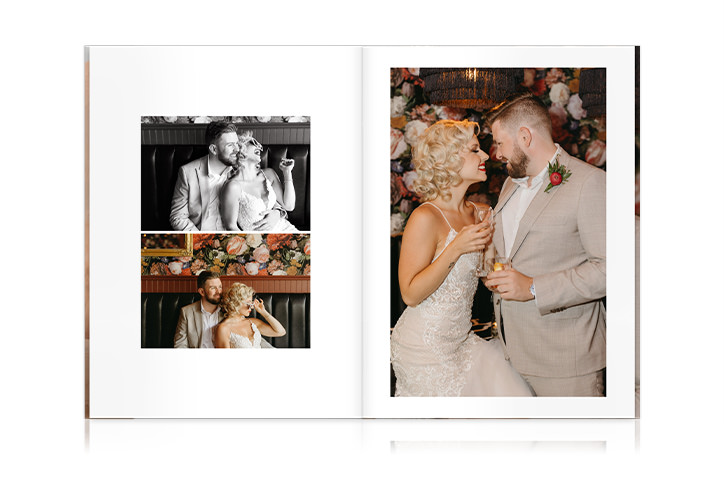 Newlywed couple sit together in vintage library holding champagne