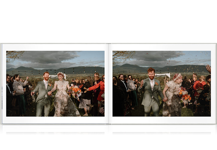 Newlywed couple walk down ceremony aisle smiling through confetti