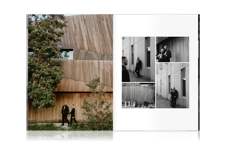 Newlywed couple in black suits hold hands walking next to modern architecture