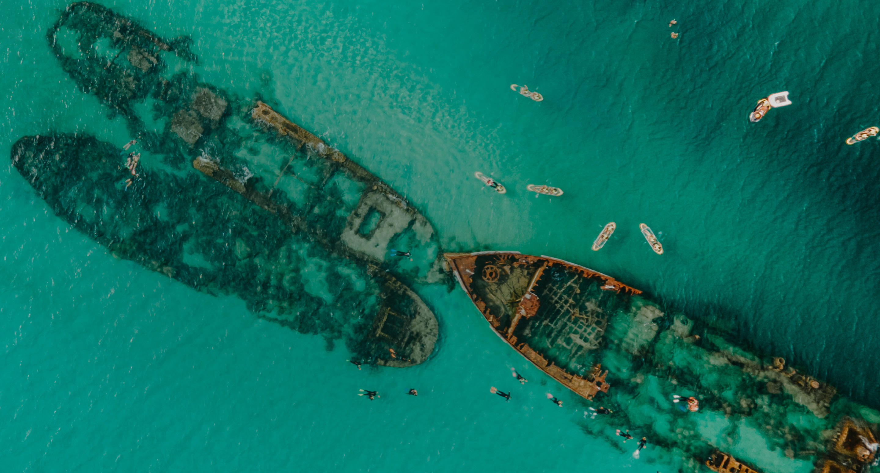 Vista aérea de um navio naufragado em um oceano tropical.