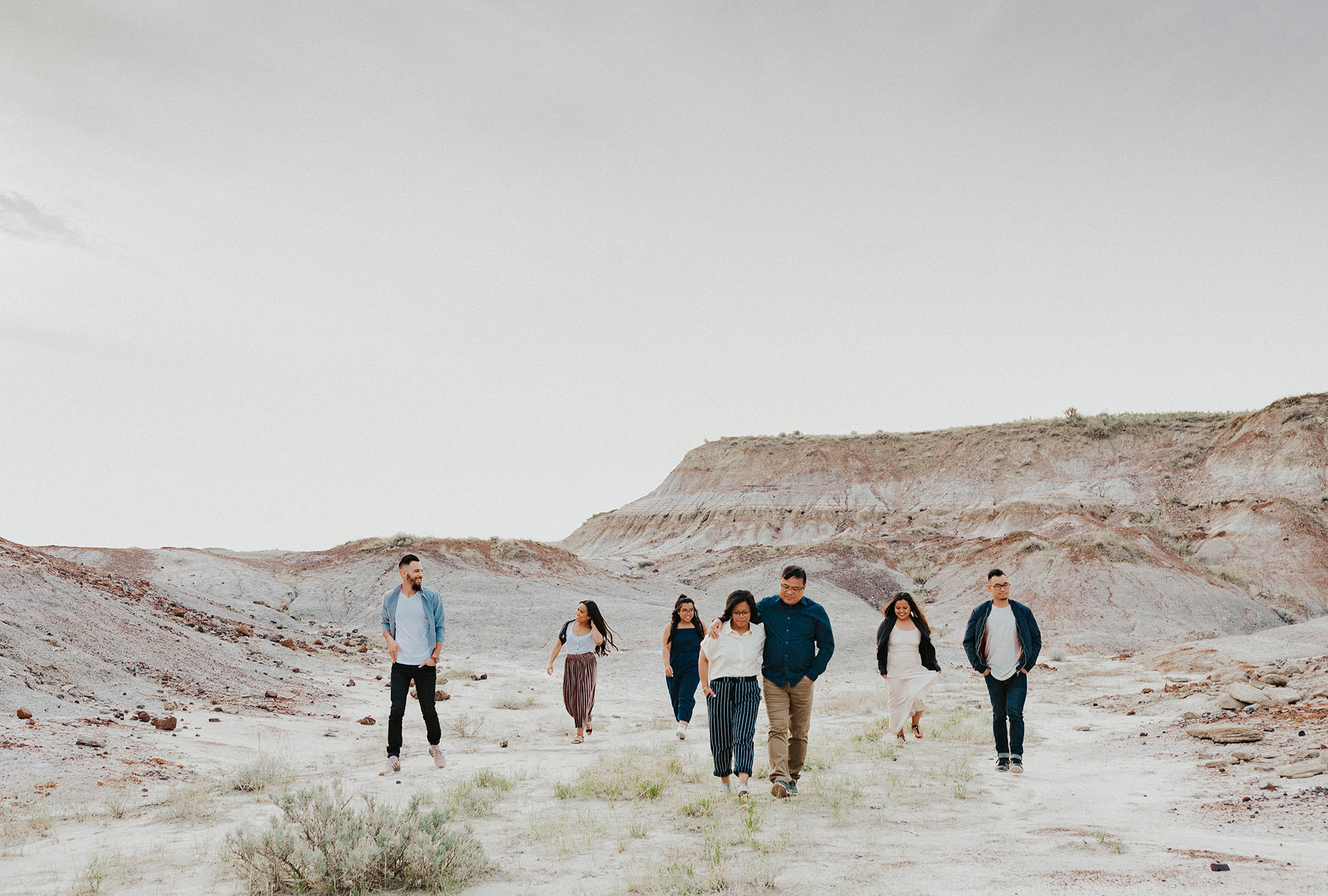 Family walk together across sandy track by canyons