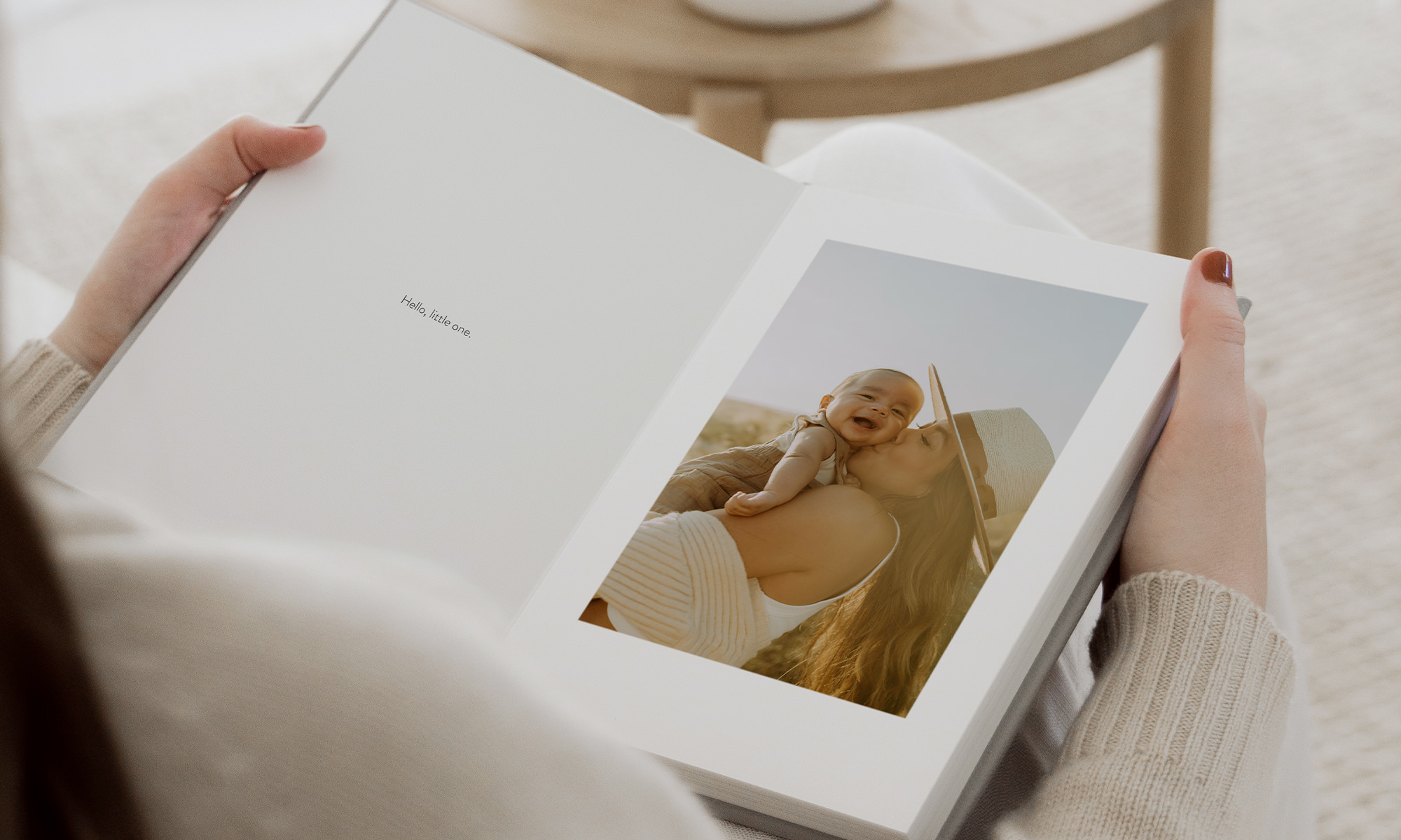 Woman holding open Portrait Premium Photo Album with mother and baby photo inside