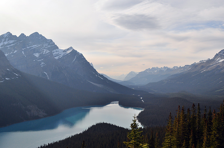 View of lake with bordering mountains and forest on a beautiful cloudy day