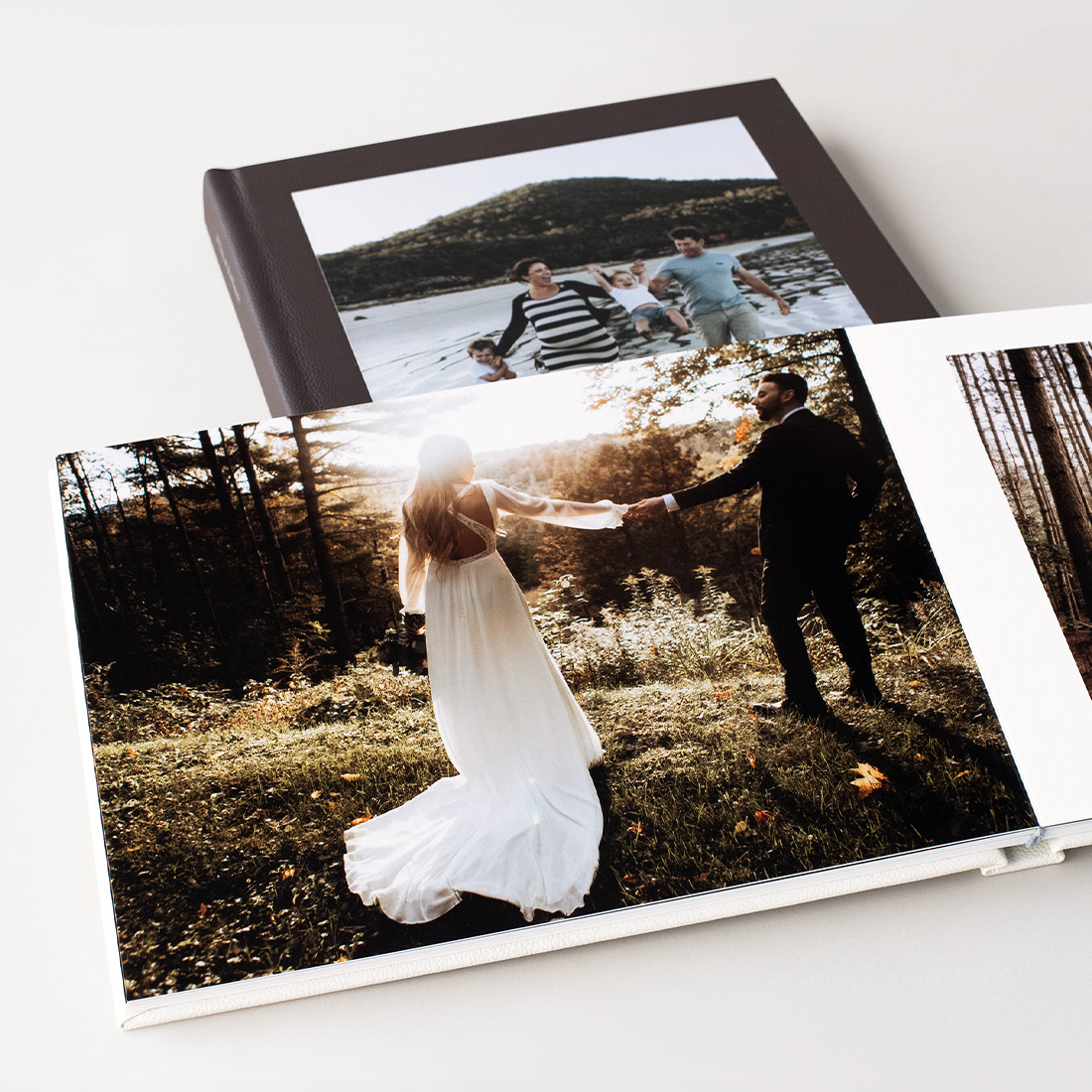 Black Leather Photo Album spread with photo of newlywed couple holding hands in the forest