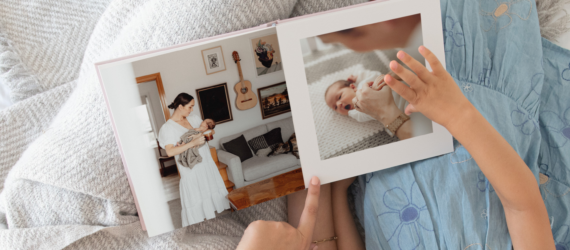 Woman and child looking through her child's large landscape baby photo book.