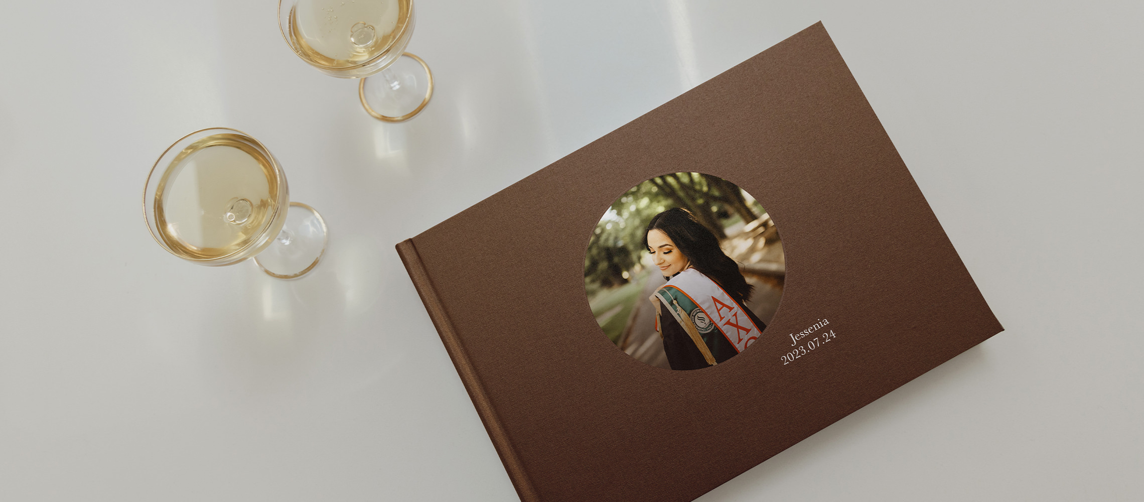 Brown Landscape Premium Graduation Photo Album with wine glasses sitting near