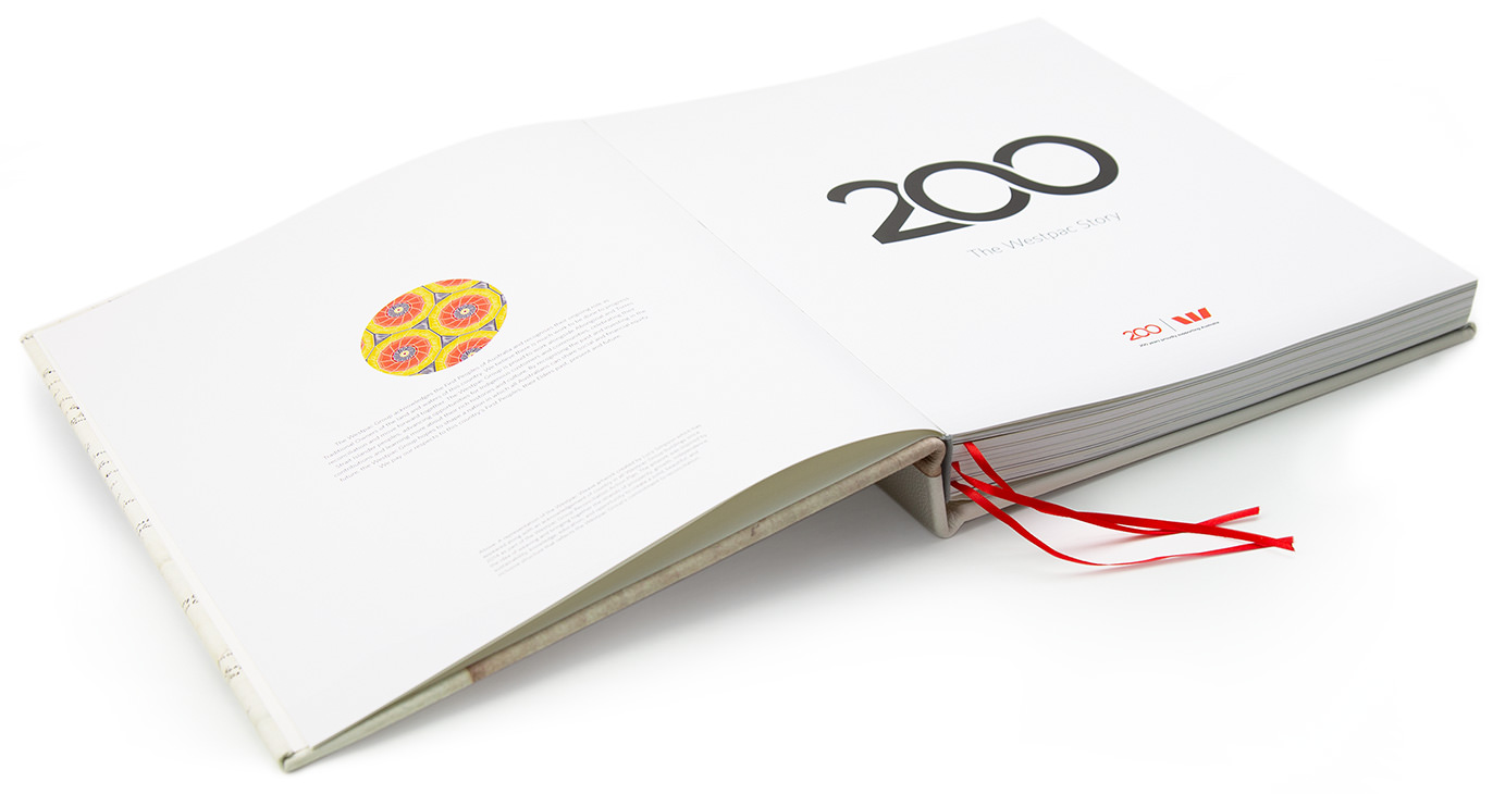 An open large square photo book showing book foreward and title page.