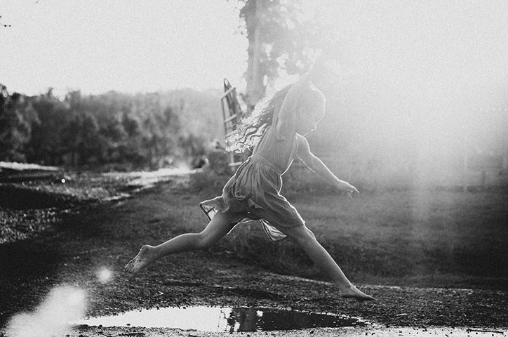 black white image of a girl jumping.