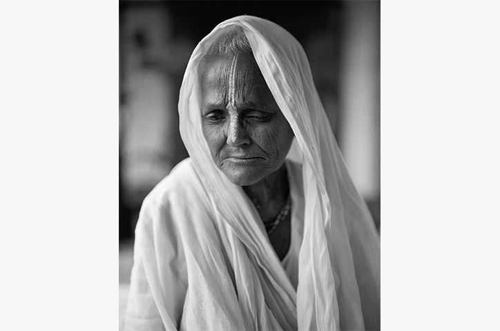 Monochrome photo of old Indian woman wearing a light hood wrap