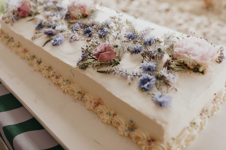 White sheet cake decorated with pink and purple flowers