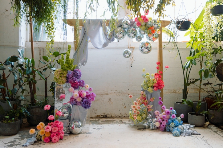 Colorful floral archway in old warehouse for rustic wedding ceremony
