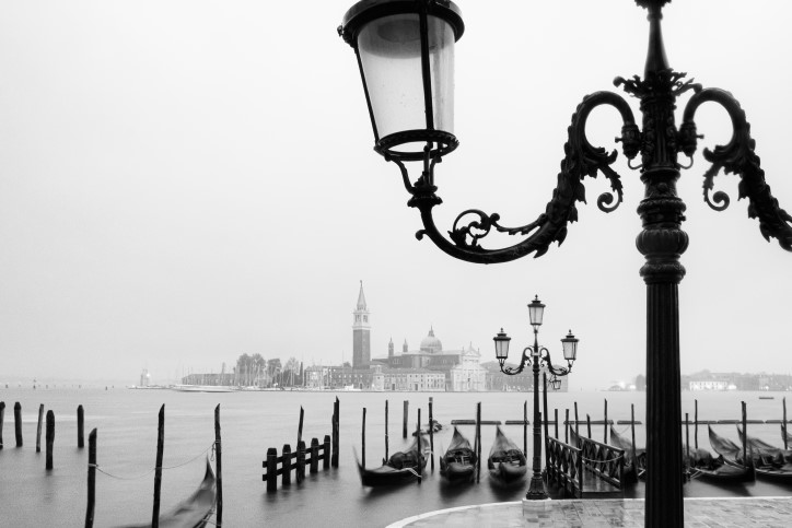 Foggy docks of Venice Italy with silhouette of old fashioned lamppost