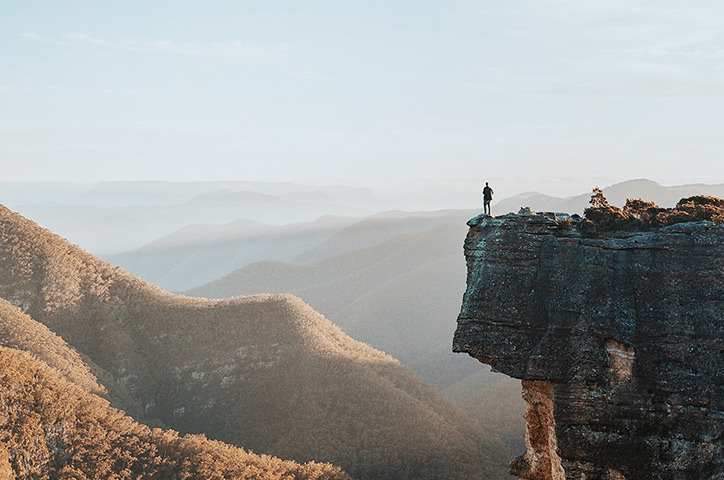 Man on cliff overlooking the hills