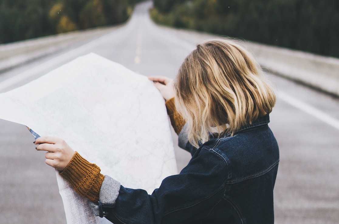 Girl on road reading a map