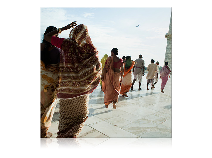 Tela quadrada com estampas de pessoas caminhando em seu colorido vestido tradicional.