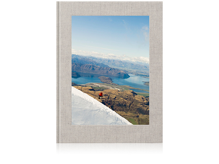 Álbum fotográfico de viagem em linho de primeira qualidade com paisagens de montanhas e lagos na capa.