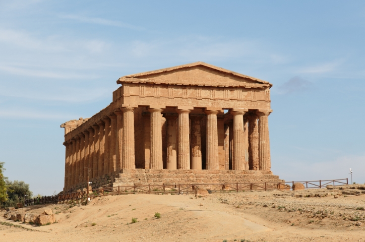 Roman building on dirt ground under bright sunlight