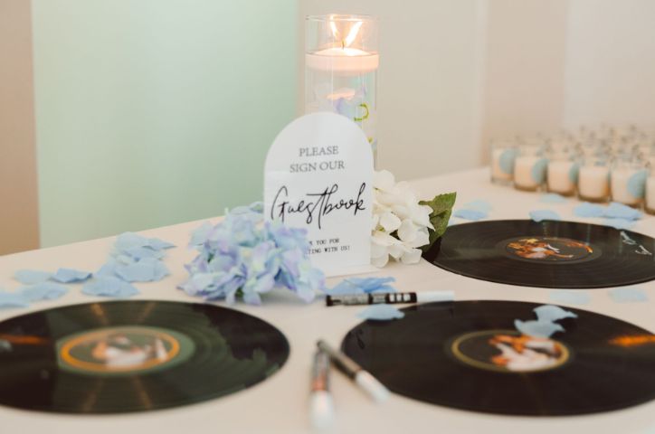 Table with vinyl shaped placements and blue floral arrangement in center.