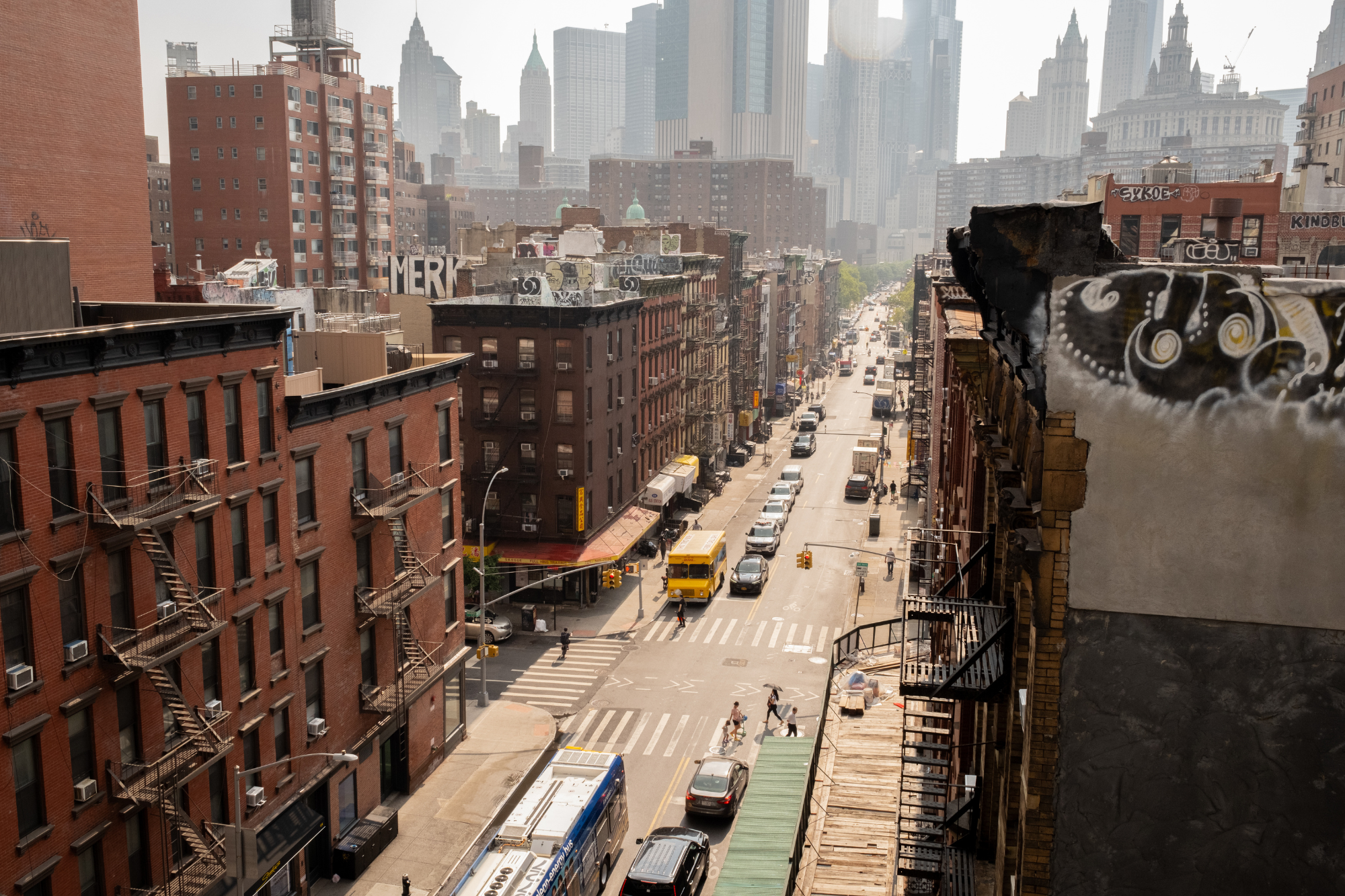 High angle overlooking streets of New York City with a brown hue and graffiti on buildings