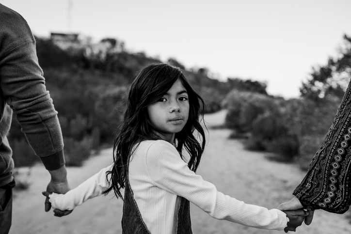 Little girl holding parents hands