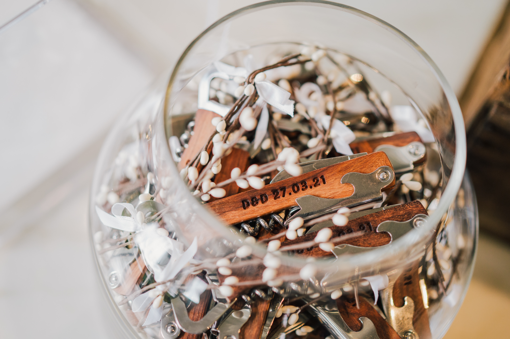 Large glass bowl of wooden multitools with burned engraved prints of initials and wedding dates