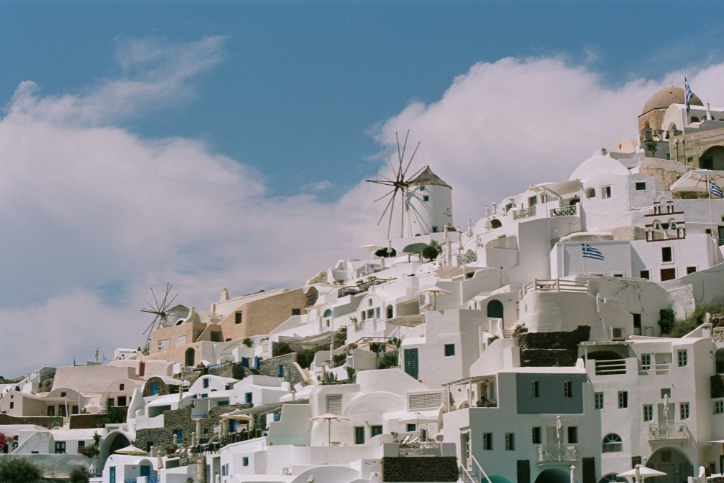 View of white buildings on cliffs of Santorini in Greece under blue sky