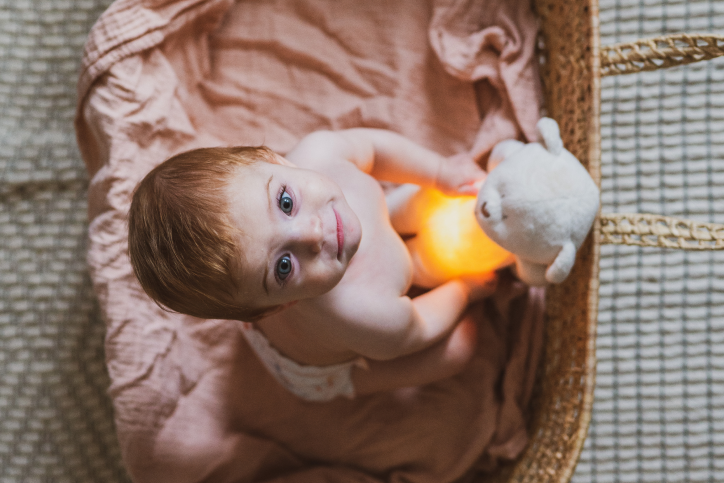 Baby with ginger hair crawling out of basket